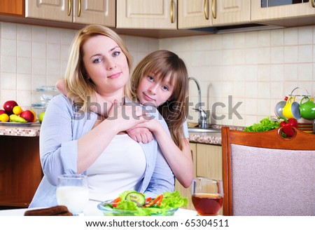 Mom and young daughter eating breakfast together in the kitchen