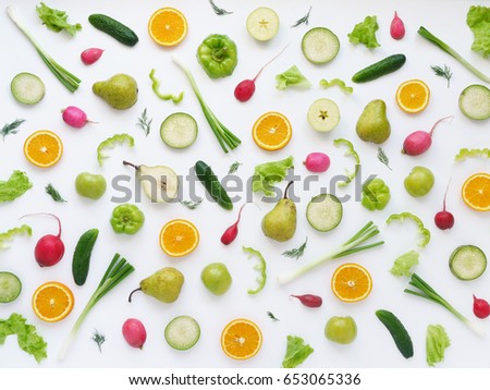 Pattern of vegetables and fruits. Abstract food background. Top view. Composition of pears, green peppers, cucumbers, green radish, green apples, pink radishes and oranges  on a white background. Royalty-Free Stock Photo #653065336