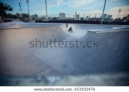 Young BMX driver making a break and checking his phone.