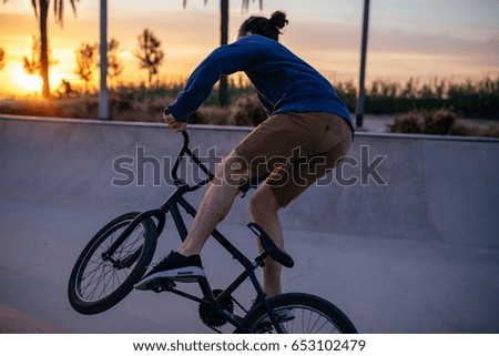 Rear view of a cyclist doing a trick on his bicycle.
