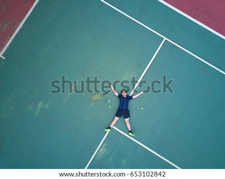 Tennis man player lay on court with racket and ball above view