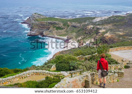 Tourist hiking at Cape Point, looking at view of Cape of Good Hope and Dias Beach, scenic travel destination in South Africa. Table Mountain National Park, Cape Peninsula. Royalty-Free Stock Photo #653109412