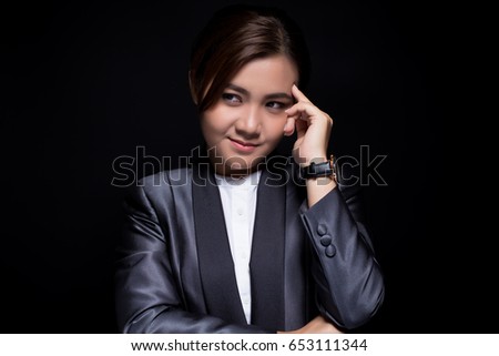 Scheming businesswoman planing something isolated on black background
