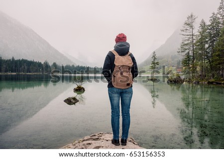 Germany. Lake Hintersee. Girl traveler with a backpack near a high mountain lake in the Alps