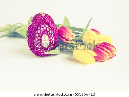 Easter decorative egg, yellow and red tylips, on white with copy space, background for greeting card, design, calendar. Easter holiday background.