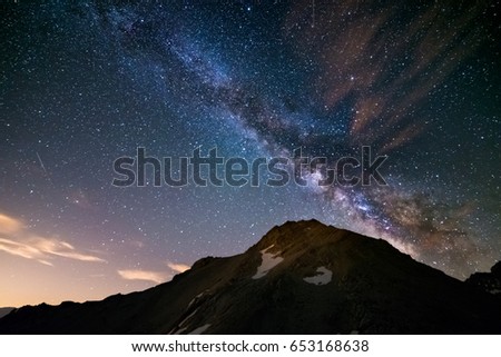 The colorful glowing core of the Milky Way and the starry sky captured at high altitude in summertime on the Italian Alps, Torino Province.