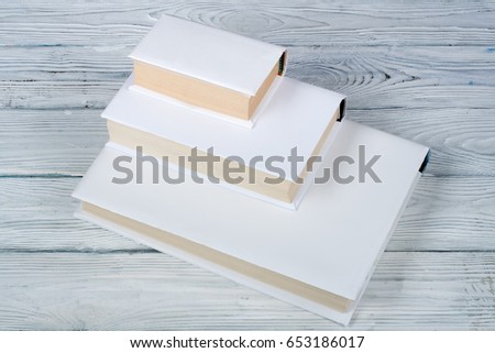 White books on wooden table, black board background. Back to school. Education business concept