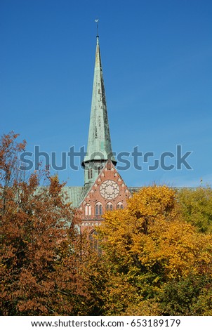 Minster in Bad Doberan (Germany), autumn trees with yellow leaves in the park of the church