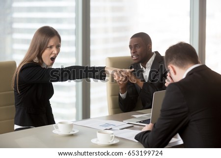 Angry female furious boss scolding employee at mixed-race team meeting, firing dismissing depressed office worker for failure, bad work results, being ineffective, pointing finger, its your fault  Royalty-Free Stock Photo #653199724