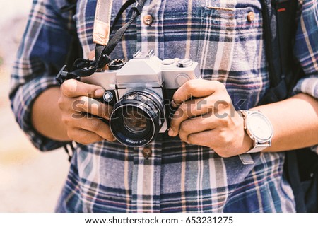 young hipster Asian woman wearing plaid shirt holding the camera vintage 