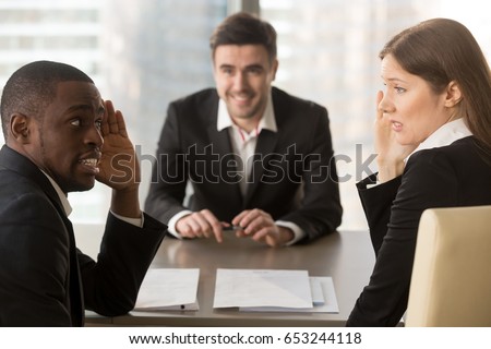 Multiracial confused employers covertly discuss job applicant, hide face with hands, look puzzled bewildered, secretly whisper during failed interview, bad negative first impression, make decision Royalty-Free Stock Photo #653244118