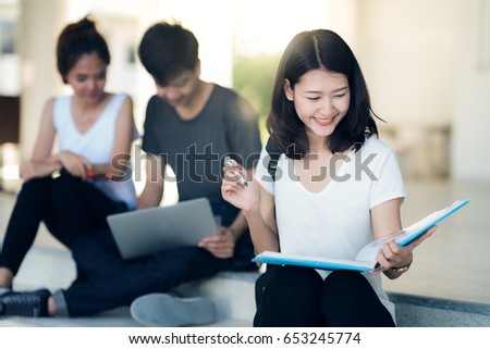 Asian student do report, read a book and home work togather at library in university Royalty-Free Stock Photo #653245774