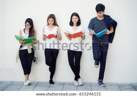 Asian student read a book in university, people group stand , friend in university.