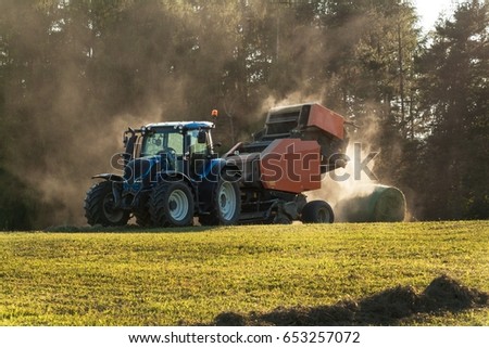 Blue tractor on the pasture.. Agricultural work on the farm in the Czech Republic