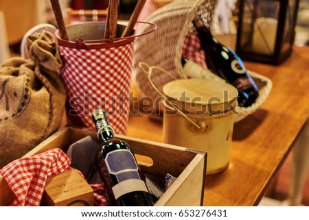 Rustic still life a bottle of wine  in a wicker basket on an  wooden kitchen table.