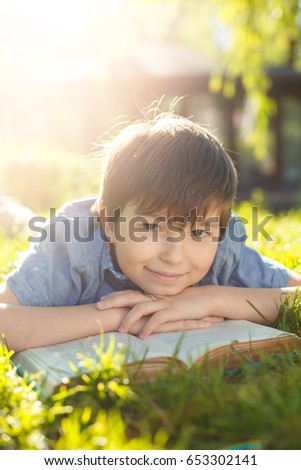 happy boy in the nature with a book