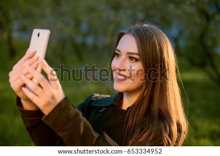 girl taking pictures of herself in nature