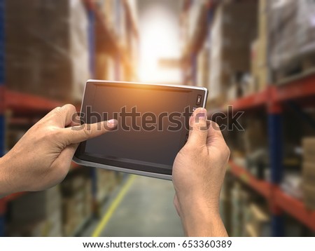 Worker Checking and Scanning Package by tablet handheld In Warehouse.