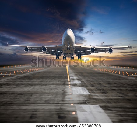 A passenger plane flying in the colorful sunset sky. Aircraft takes off from the airport runway. Airplane front view. Royalty-Free Stock Photo #653380708