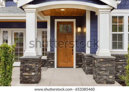 New Luxury Home Exterior Detail: New House Front Door and Covered Patio Royalty-Free Stock Photo #653385460