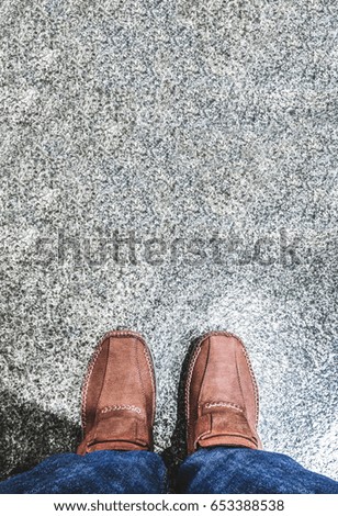 Aerial view of leather shoe with blue jean stand on grunge concrete floor, Leave space on top for adding your text