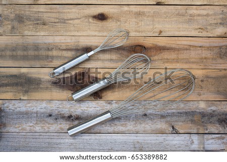 Three whisk different size on wood table