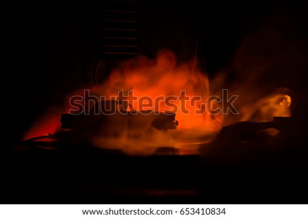 Vintage vinyl record playing on player and acoustic guitar on background with fire orange smoke. Blues concept. With Toy car