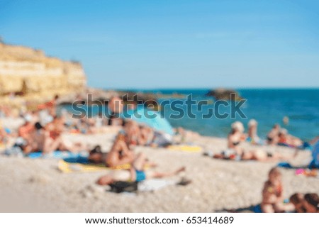 Beach scene on a busy summer day with blurred out people.