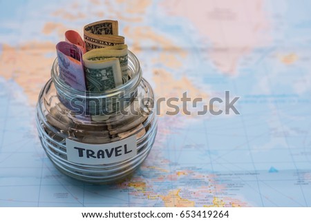 Vacation budget concept. money savings in a glass on world map for travel