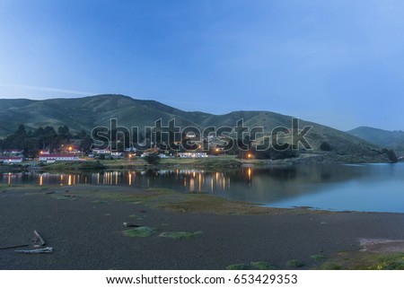 This image was taken at Rodeo Beach located in the Marin Headlands located near Sausalito, Ca. This image was captured just as the lights in the old military building were beginning to come on. Royalty-Free Stock Photo #653429353