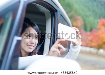 Woman taking photo inside a car