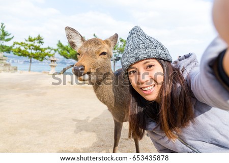 Woman taking selfie with Deer in Hiroshima