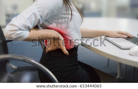 Businesswoman suffering from backache in office Royalty-Free Stock Photo #653444065