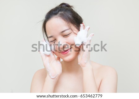 cute teenager Asian girl with baby face skin enjoy herself with bubble cleansing foam  Royalty-Free Stock Photo #653462779