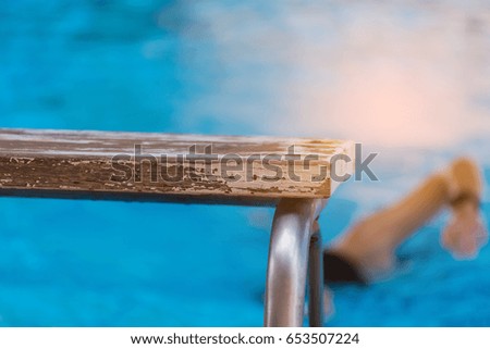 image of platform and blur people in swimming pool.(focus on platform)