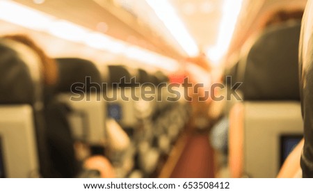 Abstract blur image of inside the airplane with people for background usage. (vintage tone)