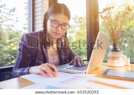 young asian woman  wearing long hair while seated in front of laptop computer ,businesswomen financial inspector and secretary making report, calculating or checking balance Service inspects document
