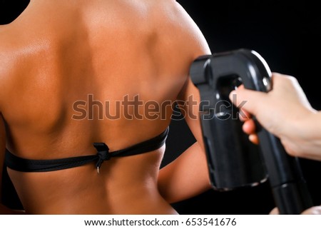 Woman body paint with airbrush in professional beauty salon Royalty-Free Stock Photo #653541676