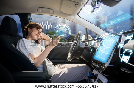 woman using smart phone in autonomous car. self driving vehicle. driverless car. autopilot. automotive technology. Royalty-Free Stock Photo #653575417