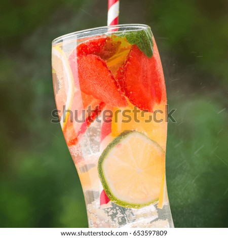 cold strawberry cocktail with lime and mint on wooden white table outdoors