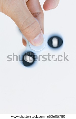 Hands holding popular fidget spinner toy on white background