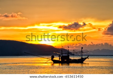 Silhouette of people in a small fishing boat moving in the background on the Sea of Chumphon Province, Thailand.