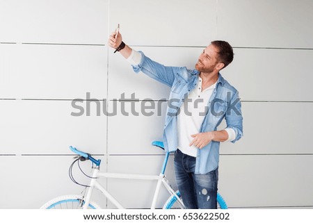 Casual guy with his vintage bicycle taking a photo with the mobile