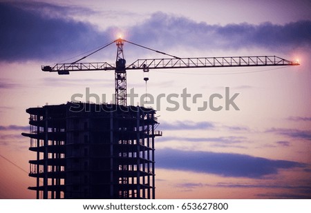 construction of a building by cranes at night