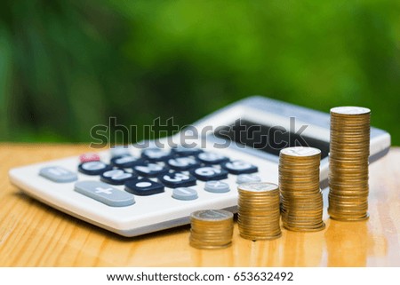 Savings, Growing coins and calculator on wood with green tree bokeh background. Financial growth, saving money, business finance wealth and success concept.