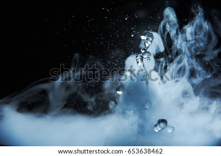 Boiling water splash with steam on black background closeup Royalty-Free Stock Photo #653638462