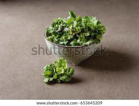 Fresh kale cabbage in a ceramic bowl. Dark gray background