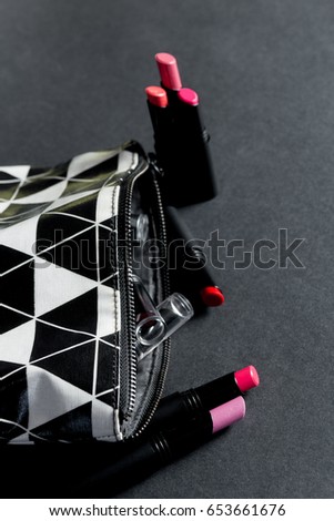Black and white make up bag with set of lipsticks. Fashion colorful. Professional makeup and beauty. Top view. Copy space.