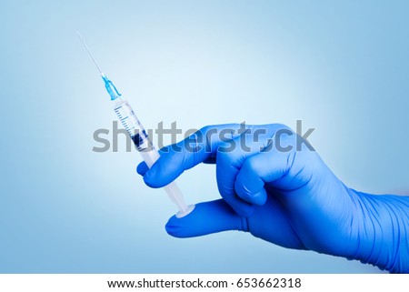 Syringe, medical injection in hand.