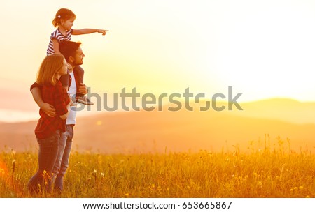 Happy family: mother father and child daughter on nature  on sunset
